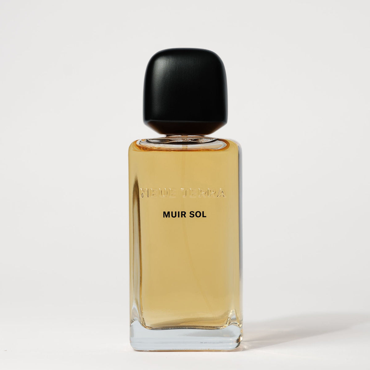 A rectangular glass perfume bottle filled with amber-colored liquid, featuring a matte black cap and the text 'MUIR SOL' printed on the front, set against a clean white background.
